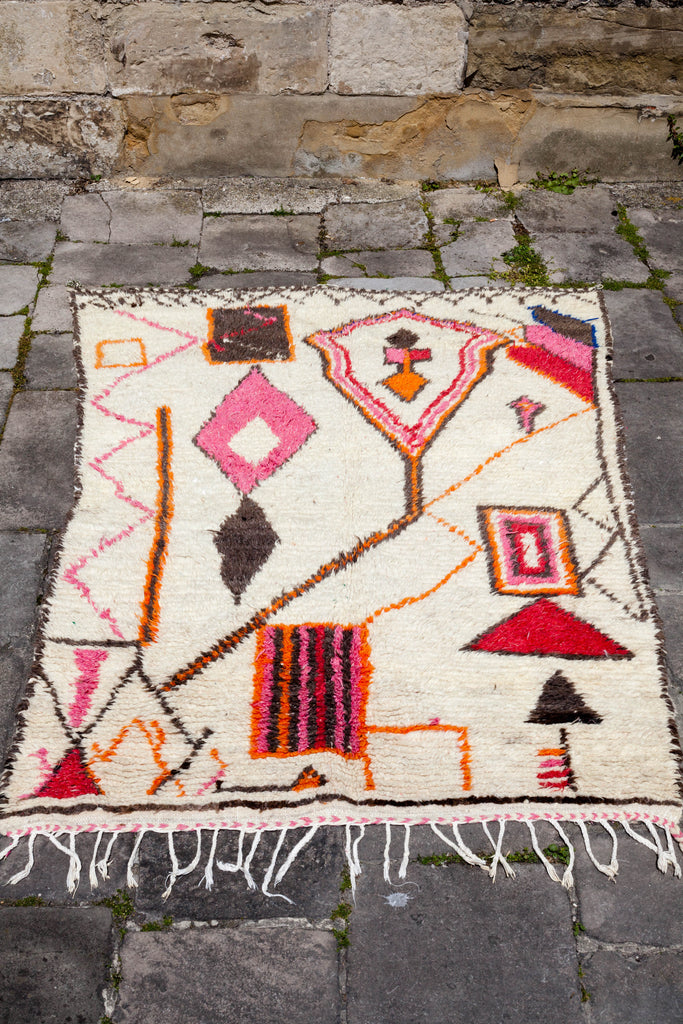 Azilal rug laid on the ground displaying the vibrant Berber symbolism that typifies Azilal rug design.