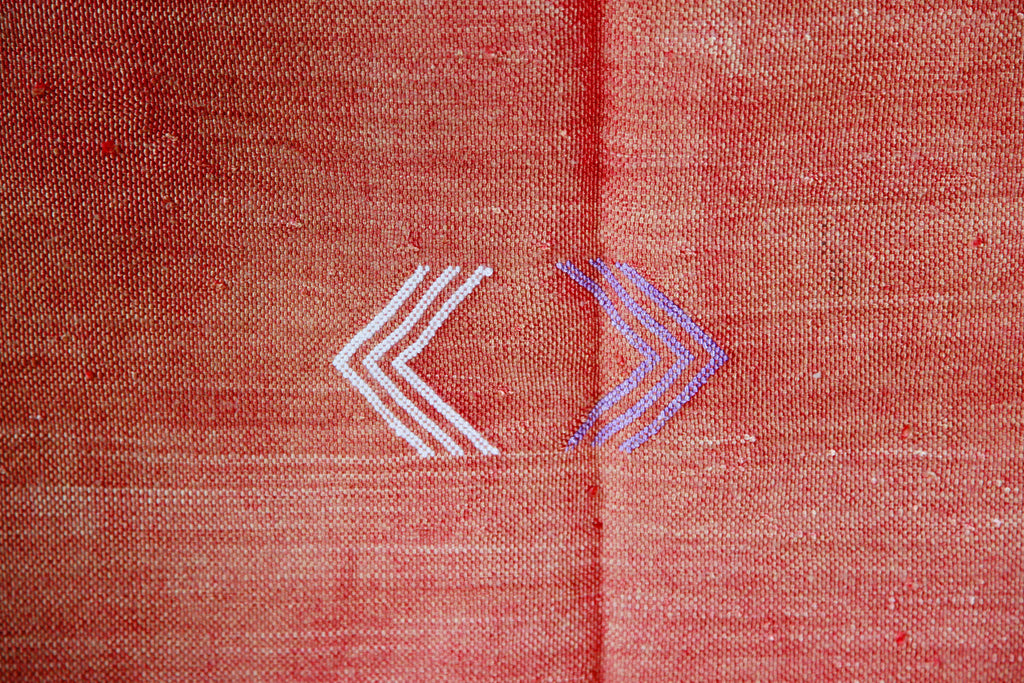 Close-up of the sunset orange Cactus silk rug, showing traditional Berber chevron symbols. 