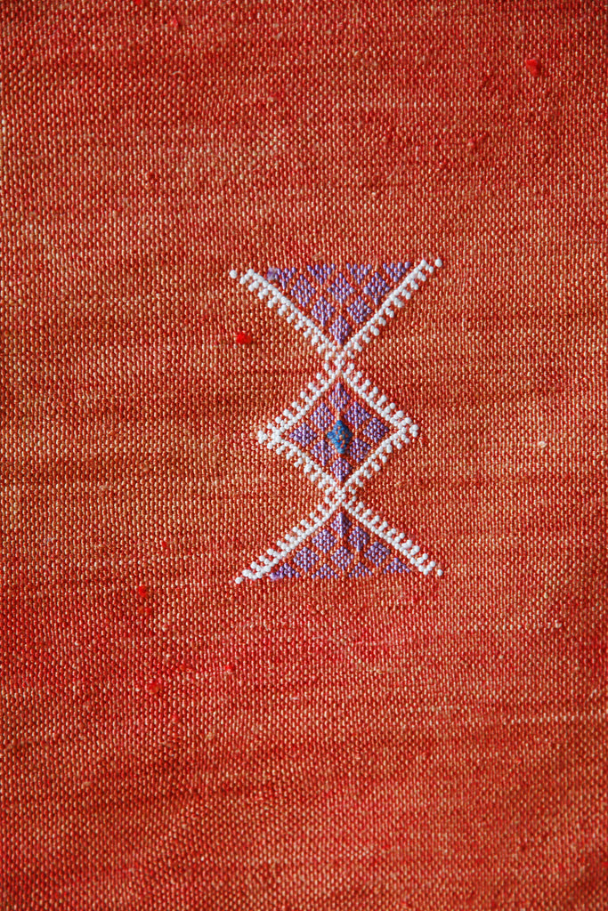 Close-up of the sunset orange Cactus silk rug, showing traditional Berber zig-zag symbols. 
