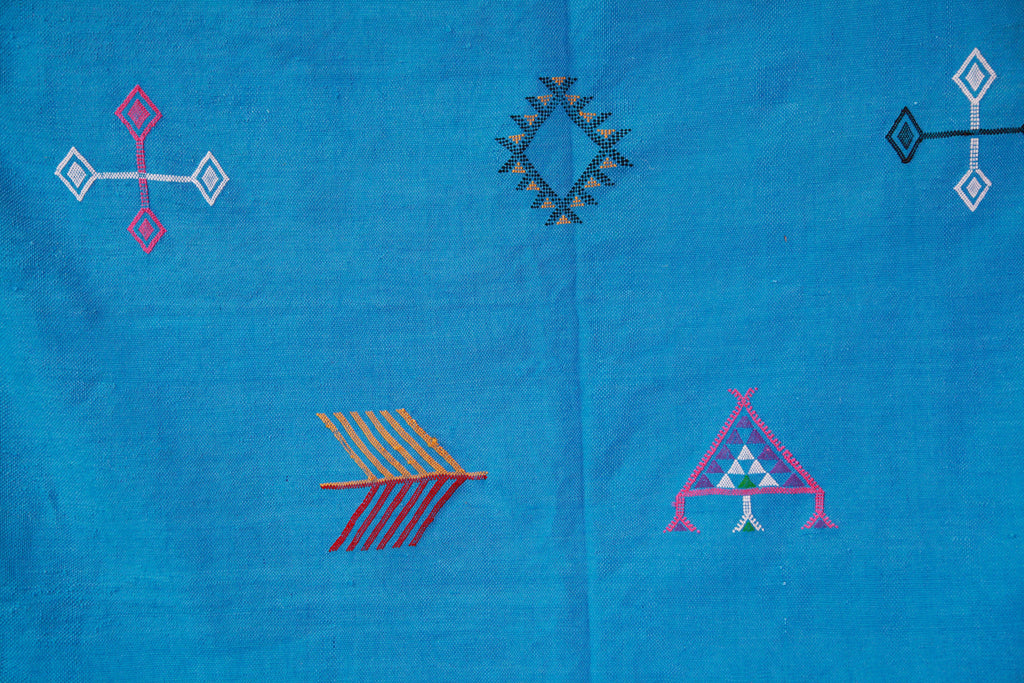 Close-up of the cactus silk kilim rug, showing finely woven, traditional Berber symbols.