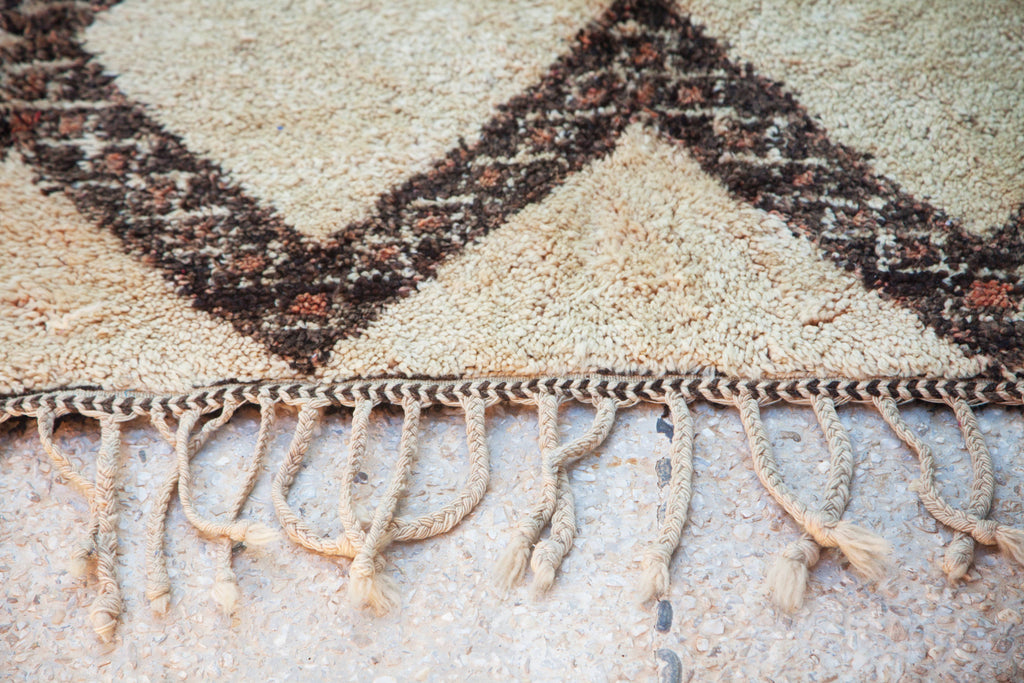 Close-up of the Marmoucha rug showing tassels and delicate edge chevron design.