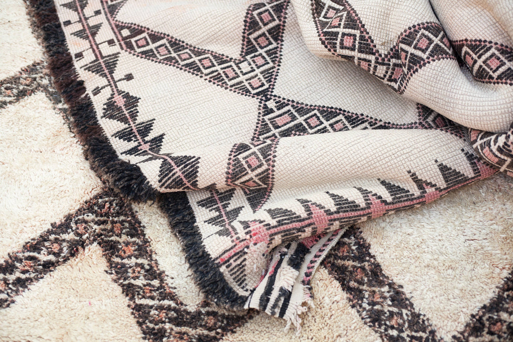 Close-up of reverse side of the Marmoucha rug showing detailed border patterns and dark grey selvedges.