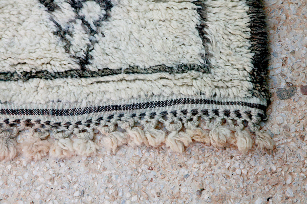 Close-up of genuine hand-made Beni Ouarain rug, showing borders, selvedges and unique crocheted tassels.